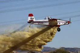 Prop plane leaving behind a cloud of dust